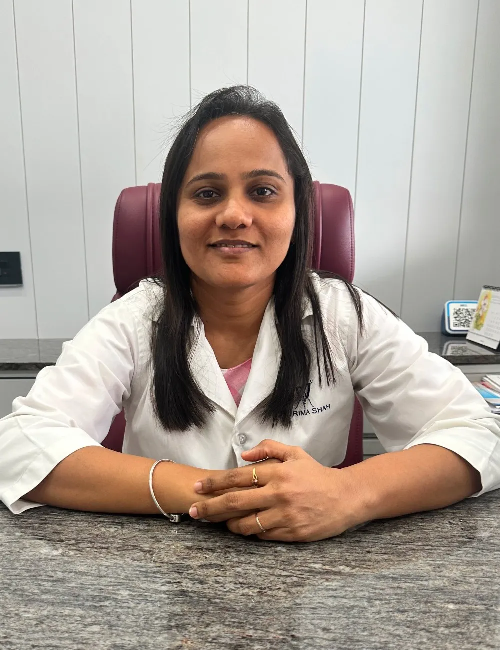 Dr. Rima J. Shah at her desk at Anaya Dental Clinic & Implant Center