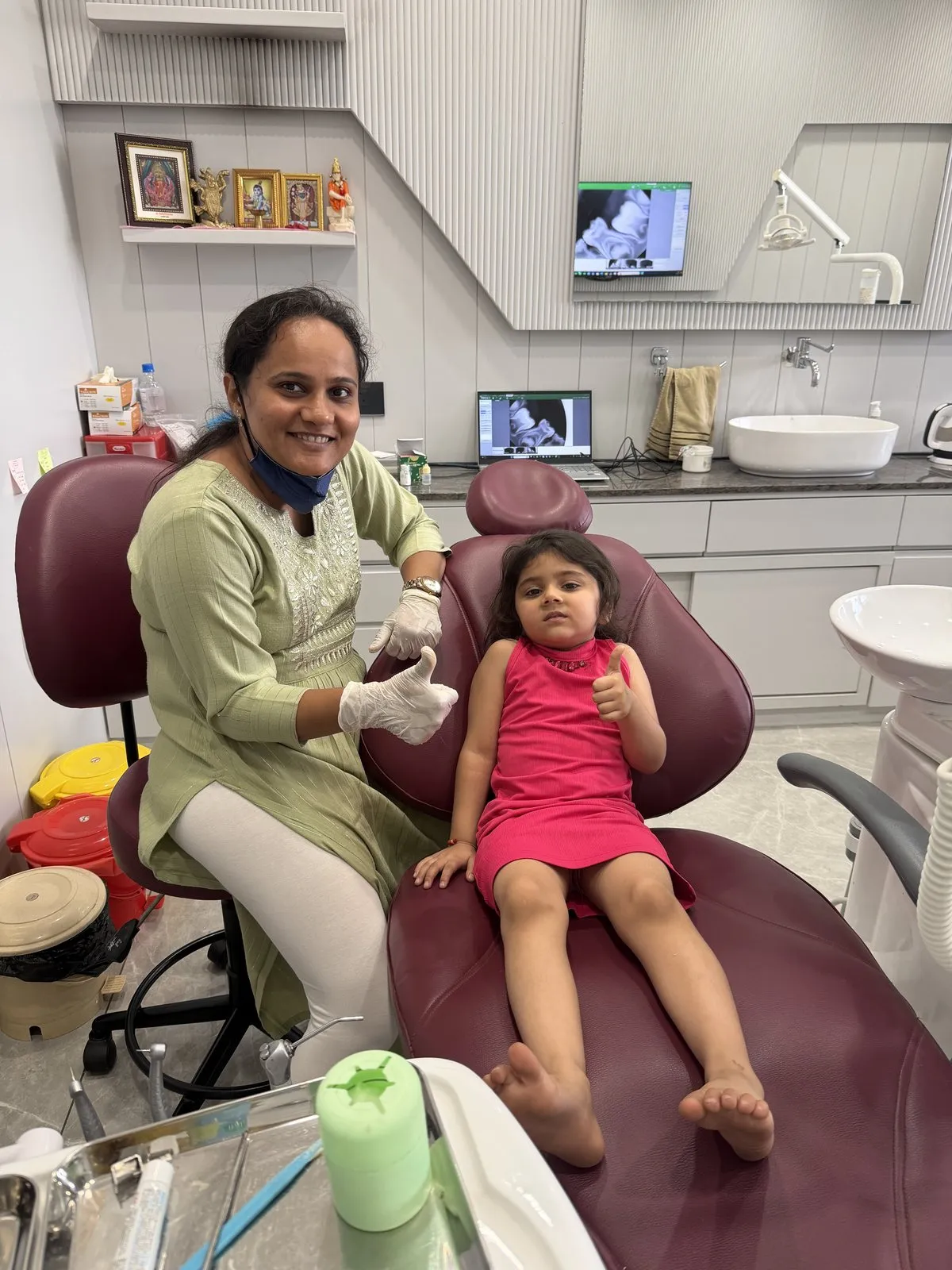 Dr. Rima Shah with a young patient giving a thumbs-up after her dental visit