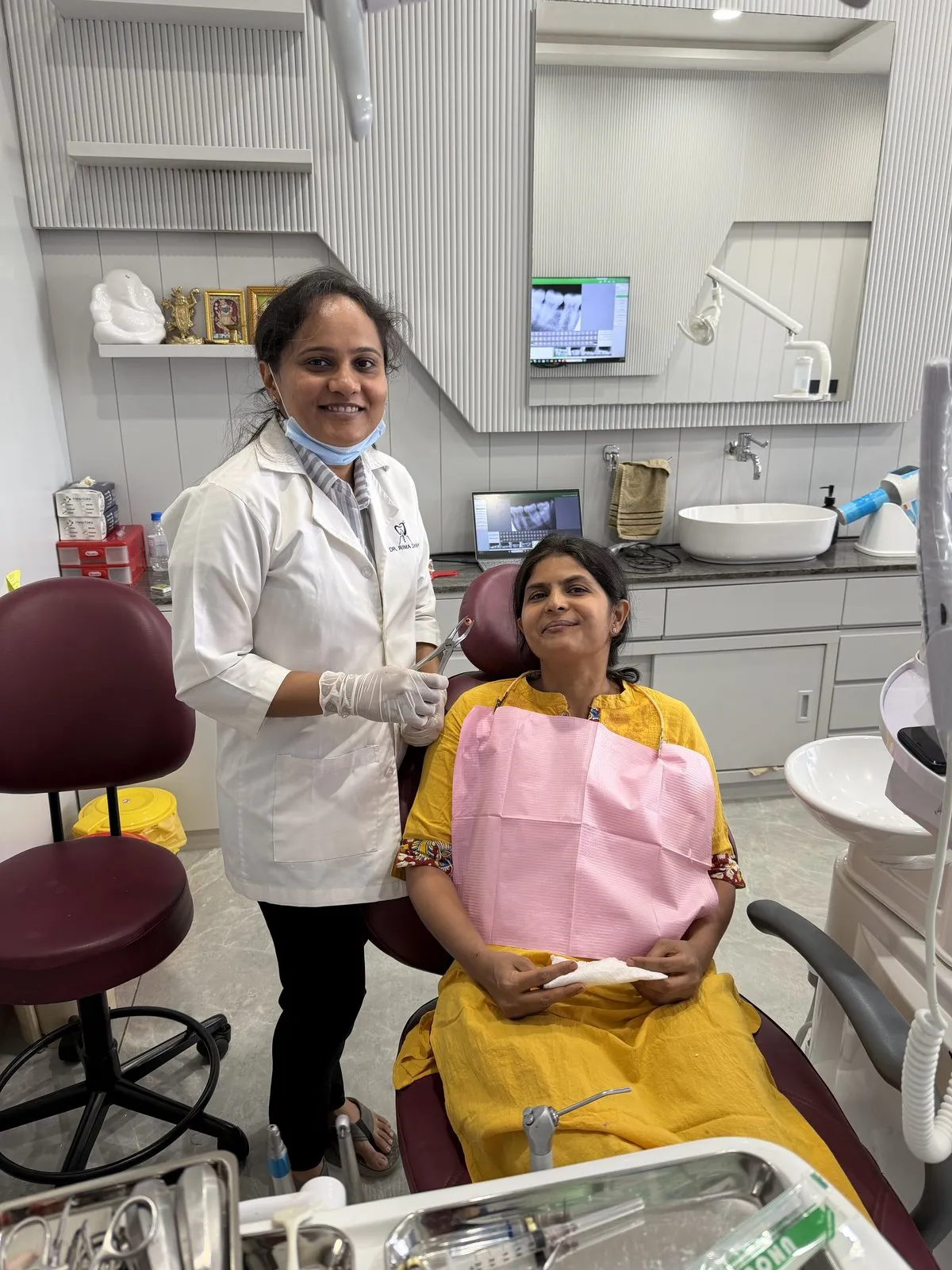 Dr. Rima Shah smiling beside a patient in the treatment chair at Anaya Dental Clinic